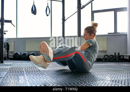 Femme faisant des exercices de remise en forme avec salle de sport fitball en classe. Engager les abdominaux de base. Image concept de mode de vie sain pour les femmes. Banque D'Images