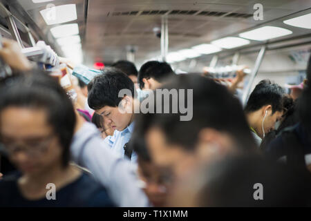 Beijing, Chine - 08 02 2016 : le peuple chinois à la recherche de leurs téléphones portables à l'intérieur d'une rame de métro à Pékin, Chine Banque D'Images