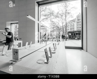 Paris, France - 19 mars 2019 : Apple iPhone smartphones XS produits s'affichent à l'intérieur du nouvel Apple Store des Champs-Elysées avec les personnes admirant kiosque devant l'holocauste après jaune protester Banque D'Images