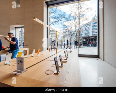 Paris, France - 19 mars 2019 : Apple iPhone smartphones XS produits s'affichent à l'intérieur du nouvel Apple Store des Champs-Elysées avec les personnes admirant kiosque devant l'holocauste après jaune protester Banque D'Images