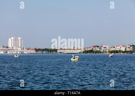 Quan Ho Tay ou Westlake district à Hanoi. Swan Lake Tay avec pédalos avec vue sur la ville sur l'arrière-plan. Le Vietnam. Banque D'Images