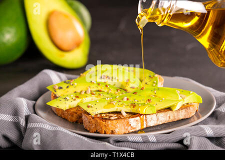 L'huile fraîche sur les sandwichs délicieux avec des tranches d'avocat et d'épices Banque D'Images