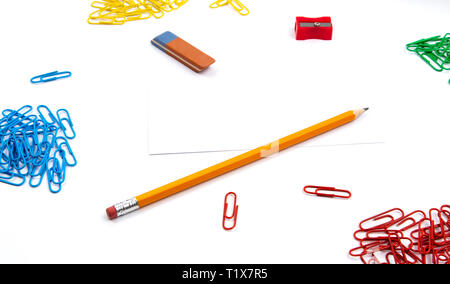 Crayon, gomme, taille-crayons, trombones se situent dans différents angles de la feuille sur un fond blanc. L'image de héros et copy space Banque D'Images