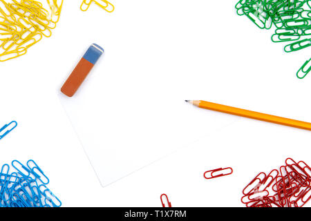 Crayon, gomme, les trombones se situent dans différents angles de la feuille sur un fond blanc. L'image de héros et copy space Banque D'Images