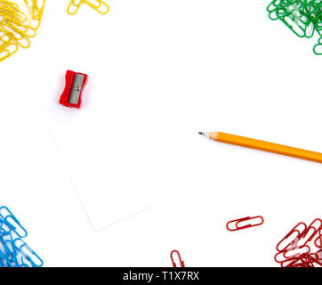 Taille-crayon, papier, agrafes se trouvent dans différents angles de la feuille sur un fond blanc. L'image de héros et copy space Banque D'Images