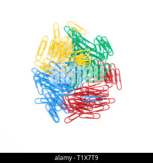Une pile de rouge, vert, bleu et jaune de la papeterie paper clips se trouvent dans le centre de la feuille sur un fond blanc. Héros haut Vue de l'image. Banque D'Images