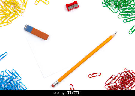 Crayon, gomme, taille-crayons, trombones se situent dans différents angles de la feuille sur un fond blanc. L'image de héros et copy space Banque D'Images