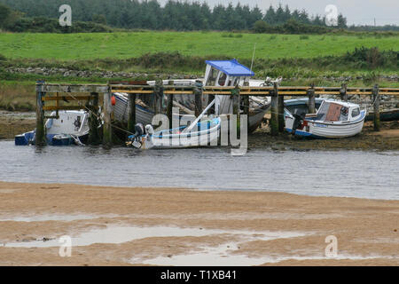 Les petits bateaux à côté d'un quai à marée basse en Irlande sur la rivière Culdaff sur la péninsule d'Inishowen, comté de Donegal. Banque D'Images