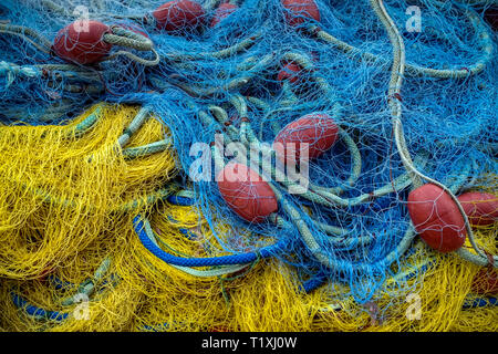 Filet de pêche bleu et jaune avec des bouées rouges Banque D'Images