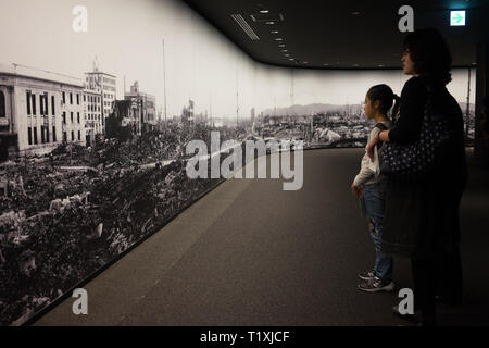 Les visiteurs à la recherche d'une grande photographie avec la destruction de la ville, après la bombe atomique en 1945. Banque D'Images