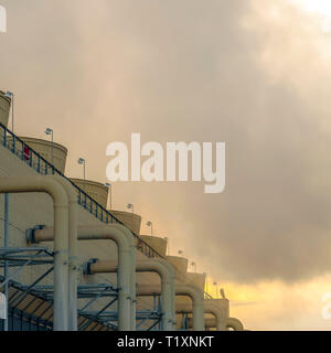 La construction de centrales à vapeur émettant au coucher du soleil. Bâtiment avec des tuyaux et des crêtes sur le mur à une centrale électrique dans l'Utah Valley. La vapeur provenant de la Gris buil Banque D'Images