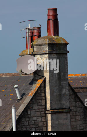 Assis sur le sommet du toit ces pots de cheminée cannelé ont résisté à la chaleur et le froid et toutes les conditions météorologiques la région a lancé sur eux pendant de nombreuses années. Banque D'Images