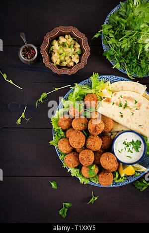 Falafel, hoummos et pita. Du Moyen Orient ou des plats arabes sur un fond sombre. La nourriture halal. Vue d'en haut. Copy space Banque D'Images