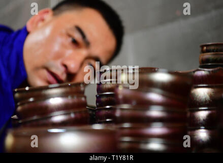 Beijing, Chine, province du Fujian. Mar 28, 2019. Zhoufu Wu, héritière de la fabrication des thés en sachet thés en vrac Jianzhan, observe des morceaux de porcelaine dans son atelier de Jianyang District de Nanping Ville, province de Fujian en Chine du sud, le 28 mars 2019. Thés en sachet thés en vrac Jianzhan, capitale de la porcelaine chinoise provient de Jianyang, remonte à plus de 1 000 ans en dynastie Song (960-1279). C'était la meilleure pour les chercheurs et écrivains thés en sachet thés en vrac d'utiliser pendant ce temps dans le thé des compétitions. Credit : Wei Peiquan/Xinhua/Alamy Live News Banque D'Images