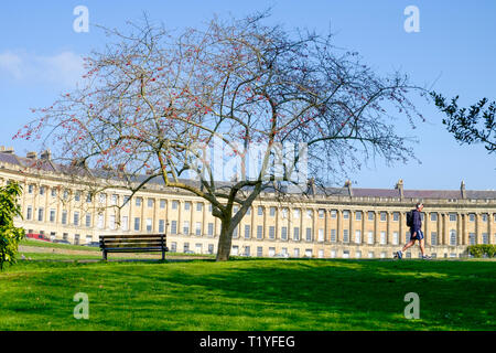 Bath, Royaume-Uni, le 29 mars, 2019. Un homme profiter de la chaleur des rayons du soleil est représenté marchant devant le Royal Crescent. Credit : Lynchpics/Alamy Live News Banque D'Images