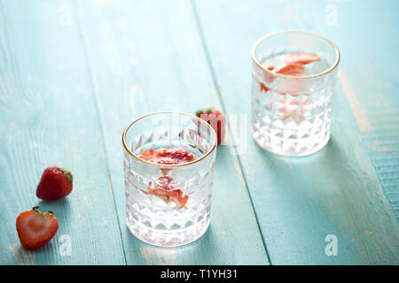 Verre de l'eau infusée à froid, avec des fraises et de fraises fraîches à côté de lui Banque D'Images