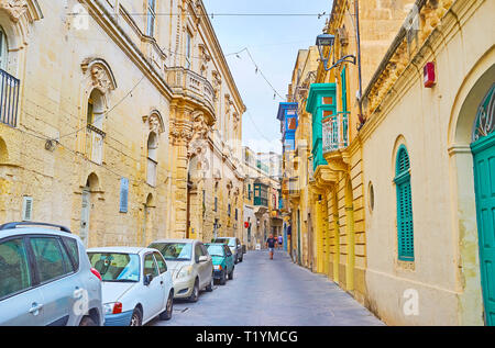 RABAT, MALTE - 16 juin 2018 : Promenade le long de l'étroite rue de la ville avec de magnifiques demeures et bâtiments historiques, décoré de guirlandes, sculpté Banque D'Images