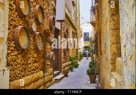 Le petit bar à vins dans l'étroite rue de Rabat est décoré avec de vieux fûts de bois, intégré dans le mur de pierre, de Malte. Banque D'Images