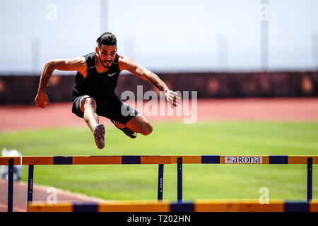Tenerife, Espagne - 21 mars 2019 : Un athlète saute par dessus un obstacle lors de la pratique sur une piste de course Banque D'Images