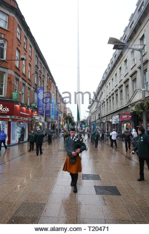 Un cornemuseur soliste dirige un mars républicaine en l'honneur de l'augmentation de 1916 à travers les rues de Dublin à Pâques. Banque D'Images