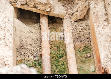 Vieux tuyaux dans une fosse de construction. La fosse remplie d'eau  souterraine et d'eau de pluie en hiver Photo Stock - Alamy