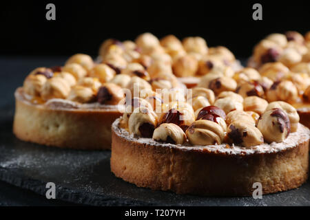 Tarte aux noix et miel sur fond sombre. Banque D'Images