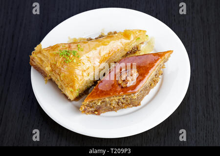 Dessert traditionnel arabe baklava aux noix et à la cardamome, sur une table en bois. Des baklava aux noix et miel Banque D'Images