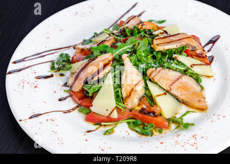 Salade avec du thon grillé, Parmesan, tomates et roquette, aromatisée à la sauce balsamique et d'huile d'olive Banque D'Images