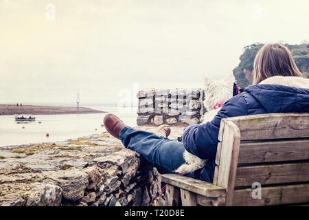 Une femme et un chien Scottie regardant le ferry pedestrean entrent à Shaldon, Devon. Février 2019 Banque D'Images
