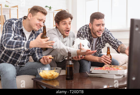 Déçu friends watching football game, mécontents de la perte, de boire une bière et manger à la maison Banque D'Images