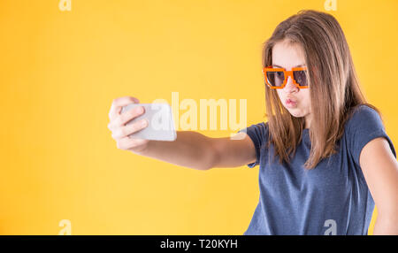 Portrait de crazy girl avec lunettes rétro faisant plus de selfies fond jaune. Banque D'Images