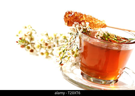 Miel de fleurs joliment décorées dans un verre. Sur le dessus il y a un sucre candy stick. Banque D'Images