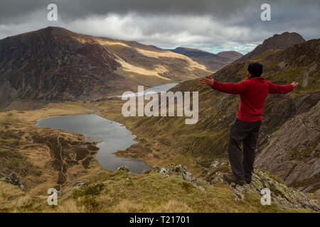 Un mâle hill walker à admirer la vue de Llyn Idwal et l'Ogwen Valley de Devil's Kitchen, Parc National de Snowdonia, Pays de Galles Banque D'Images