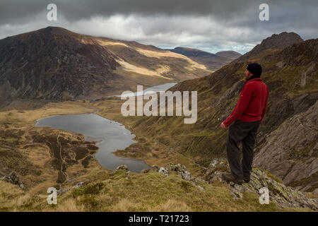 Un mâle hill walker à admirer la vue de Llyn Idwal et l'Ogwen Valley de Devil's Kitchen, Parc National de Snowdonia, Pays de Galles Banque D'Images