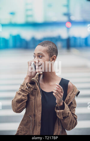 Une femme afro-brésiliennes à Sao Paulo en utilisant son téléphone dans la rue Banque D'Images