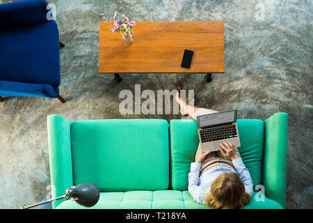 Vue de dessus de businesswoman working on laptop sur la table turquoise en espace de coworking Banque D'Images