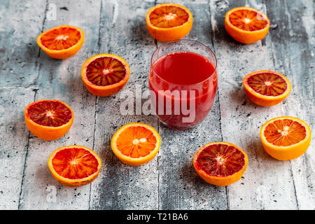Moitiés d'orange sanguine et un verre de jus d'orange sanguine Banque D'Images