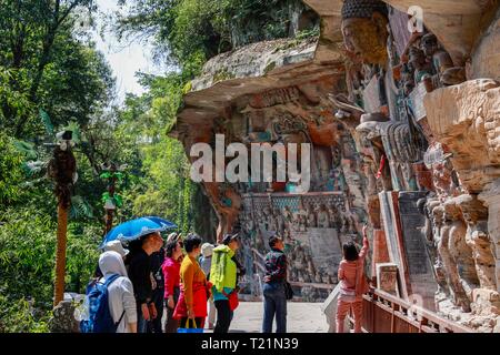 Chongqing, Chine. Mar 29, 2019. Les touristes voir sculptures sur roc à la zone panoramique de Sculptures rupestres de Dazu Dazu dans district de Chongqing, au sud-ouest de la Chine, le 29 mars 2019. Les sculptures datant du 9ème au 13ème siècles ont été inscrits sur la liste du patrimoine mondial par l'UNESCO en 1999. Credit : Liu Chan/Xinhua/Alamy Live News Banque D'Images