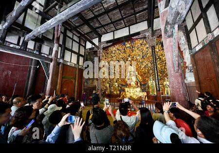 Chongqing, Chine. Mar 29, 2019. Les touristes de prendre des photos de statues au Bodhisattva Sculptures rupestres de Dazu scenic area dans le district de Dazu de Chongqing, au sud-ouest de la Chine, le 29 mars 2019. Les sculptures datant du 9ème au 13ème siècles ont été inscrits sur la liste du patrimoine mondial par l'UNESCO en 1999. Credit : Liu Chan/Xinhua/Alamy Live News Banque D'Images