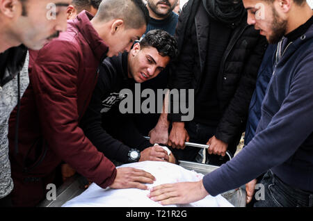 La bande de Gaza. 30Th Mar, 2019. Les proches des 20 ans, Mohammed Saad, qui a été tué par des soldats israéliens", faire des coups de son corps sur la frontière Gaza-Israel, est de la ville de Gaza, le 30 mars 2019. Un Palestinien a été abattu par des tirs de soldats israéliens' le samedi avant l'aube à l'est de la ville de Gaza, selon des sources médicales palestiniennes. Mohammed Saad, 20 ans, a été tué par des éclats d'un obus de char tiré par des soldats israéliens qui l'a touché directement dans la tête est de la ville de Gaza, un porte-parole du Ministère de la santé, de la bande de Gaza Ashraf al-Qedra, a dit dans une déclaration. Credit : Yasser Qudih/Xinhua/Alamy Live News Banque D'Images