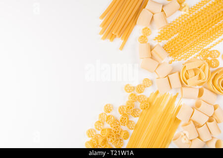 Une photo prise à la verticale de différents types de pâtes, y compris spaghetti, penne, fusilli, et d'autres, flay déposer sur un fond blanc avec une place pour le texte Banque D'Images