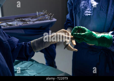 Chirurgiens holding surgical couteau en salle d'opération pendant la chirurgie Banque D'Images