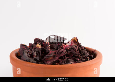 Pétales d'hibiscus à sec dans le pot en argile isolé sur fond blanc Banque D'Images