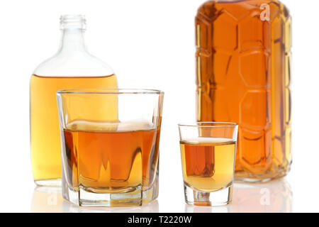 Tasse en verre et bouteille de whiskey sur fond blanc Banque D'Images