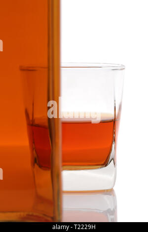 Tasse en verre et bouteille de whiskey sur fond blanc Banque D'Images