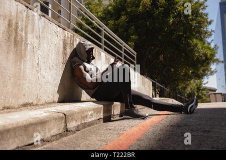 Man using mobile phone on side walk Banque D'Images