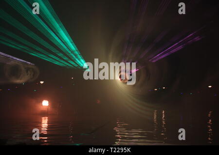 Faisceaux laser lors d'un spectacle public en plusieurs couleurs à l'eau du canal (Ringvaart) Zuidplaspolder à Nieuwerkerk aan den IJssel Banque D'Images