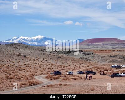 Les voitures en stationnement et les gens qui marchent sur la Réserve Navajo, NE de Flagstaff, Arizona avec San Francisco Peaks enneigées au loin. Banque D'Images