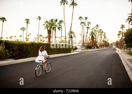 USA, California, Palm Springs, woman riding bicycle dans la rue Banque D'Images