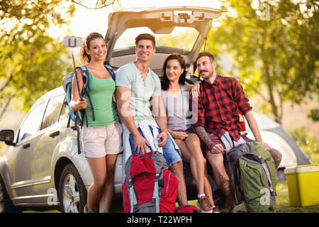 Groupe de jeunes amis hipster selfies faire photo avec smartphone dans le coffre sur le voyage de camping. Les activités de plein air les drôles de jeunes étudiants, loin de chez vous. Banque D'Images